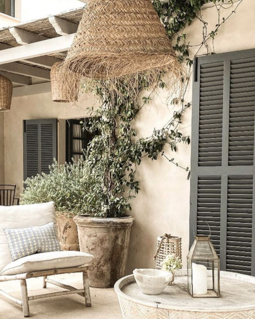 A outside patio area with stylish decor and rattan ceiling lamp